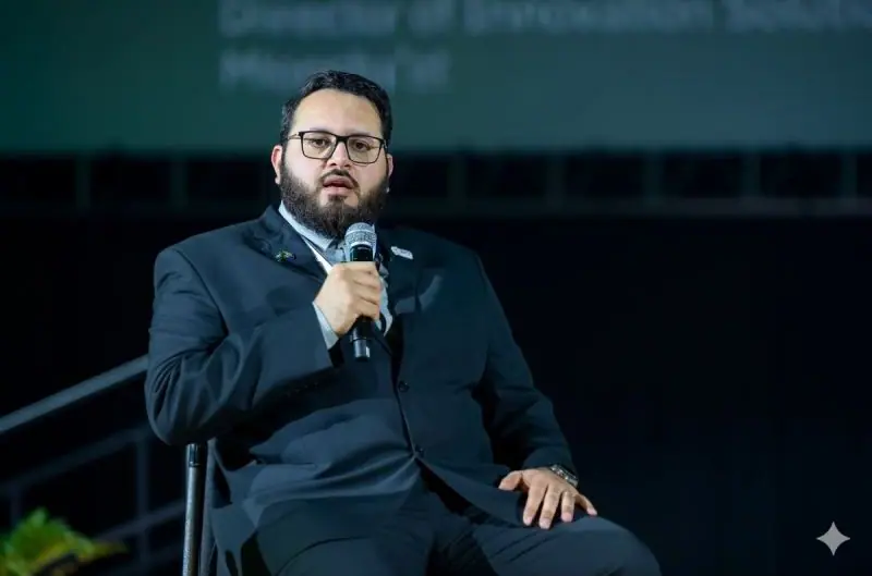 Ahmed Alshareef speaking into a microphone on the panel stage