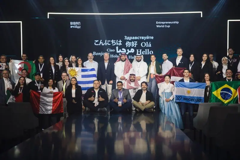 Global finalists holding their national flags on the Entrepreneurship World Cup stage